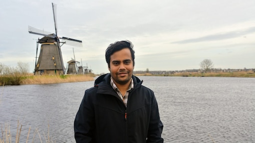 Anirrudh standing in front of windmill