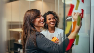 Woman writing on board and smiling