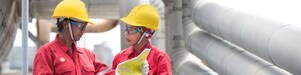 Employees on site discussing work and referring to clipboard
