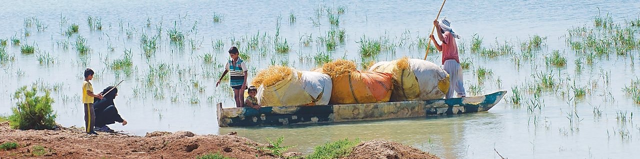 Local people cross the flooded Hawizeh Marshes, near the Majnoon project in Iraq