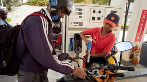 Woman shell attendant helping motorcyclist refuel his motorbike