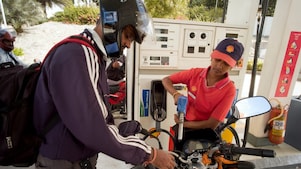 woman shell attendant helping motorcyclist refuel his motorbike