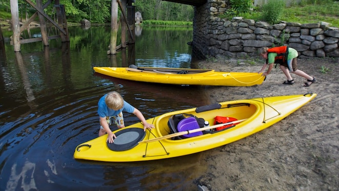 Children launching canoes into the water