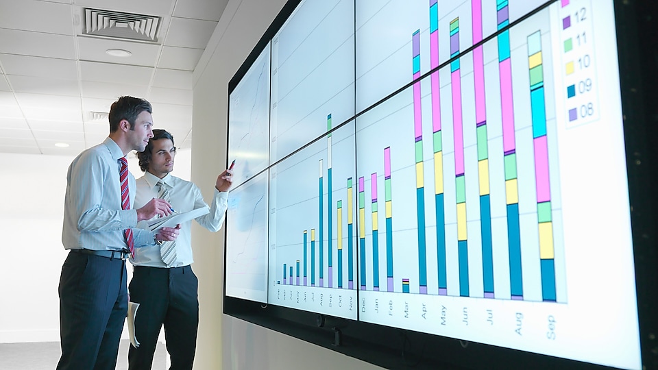 Men looking at data graph on screen