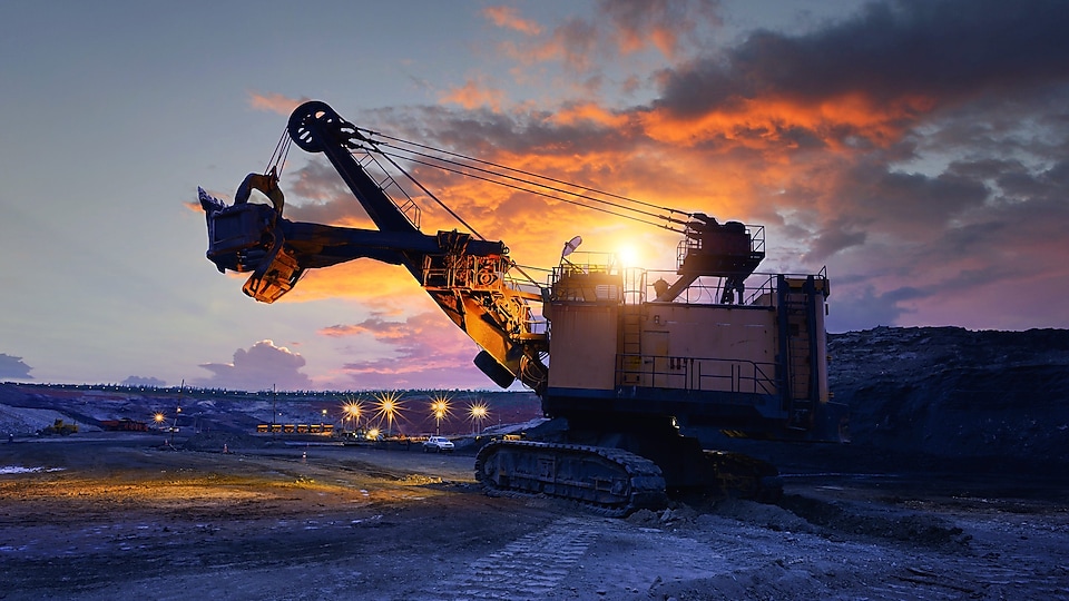 Excavator on a mining site working in dusk