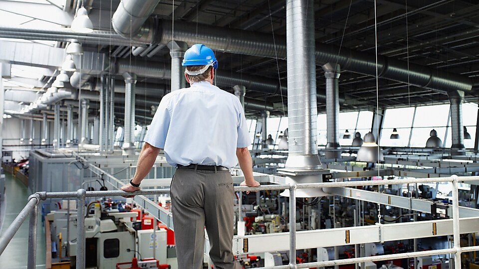 Manager overlooking factory production floor