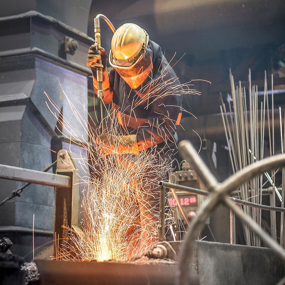 Worker in protective clothing at work in a steel foundry