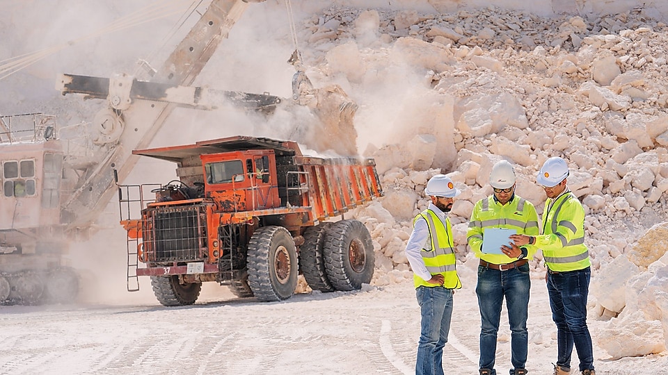 Workers and machinery at cement quarrying site