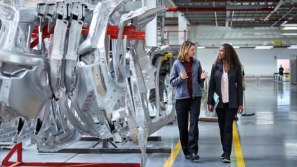 Women walking through robotics manufacturing plant