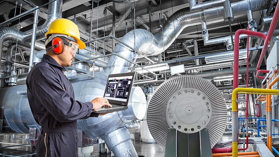 Engineer using laptop computer for maintenance in thermal power plant