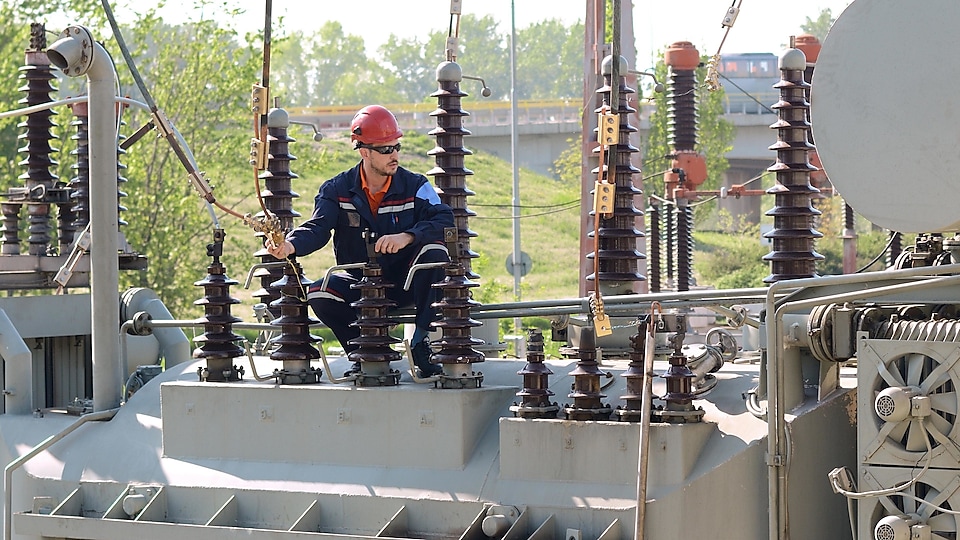 Electrician checking electricity transformer equipment.