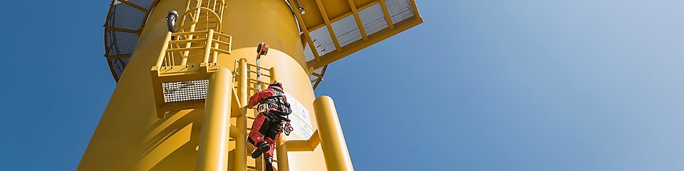 Power engineer climbing wind turbine for maintenance