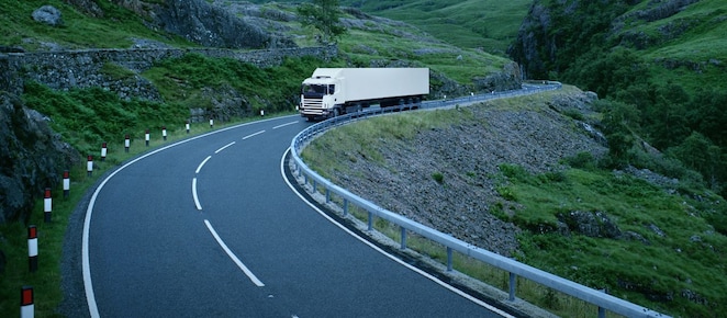 White lorry on road through rural landscape, Scotland