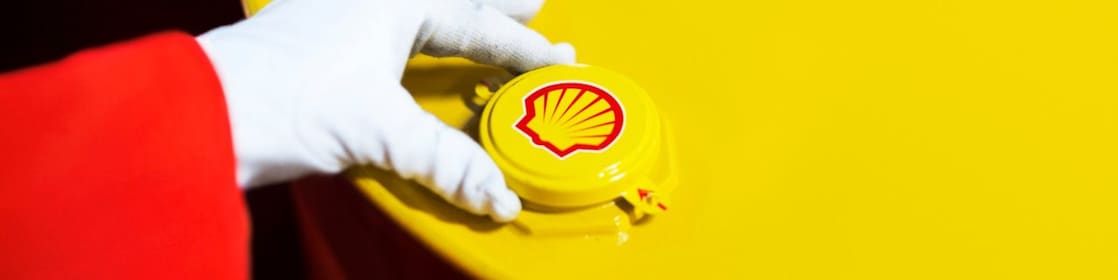 A Shell expert adjusts the lid of a barrel of lubricant displaying the Shell logo