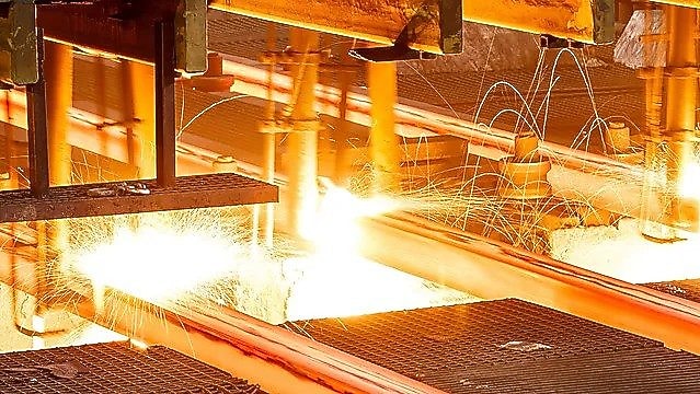 Workers in hard hats in a metal factory