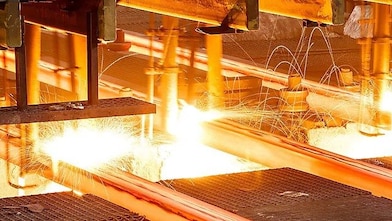 Workers in hard hats in a metal factory