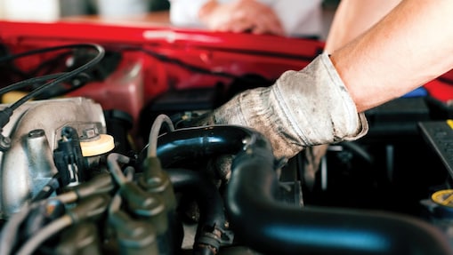 Mechanic wearing gloves fixing an engine