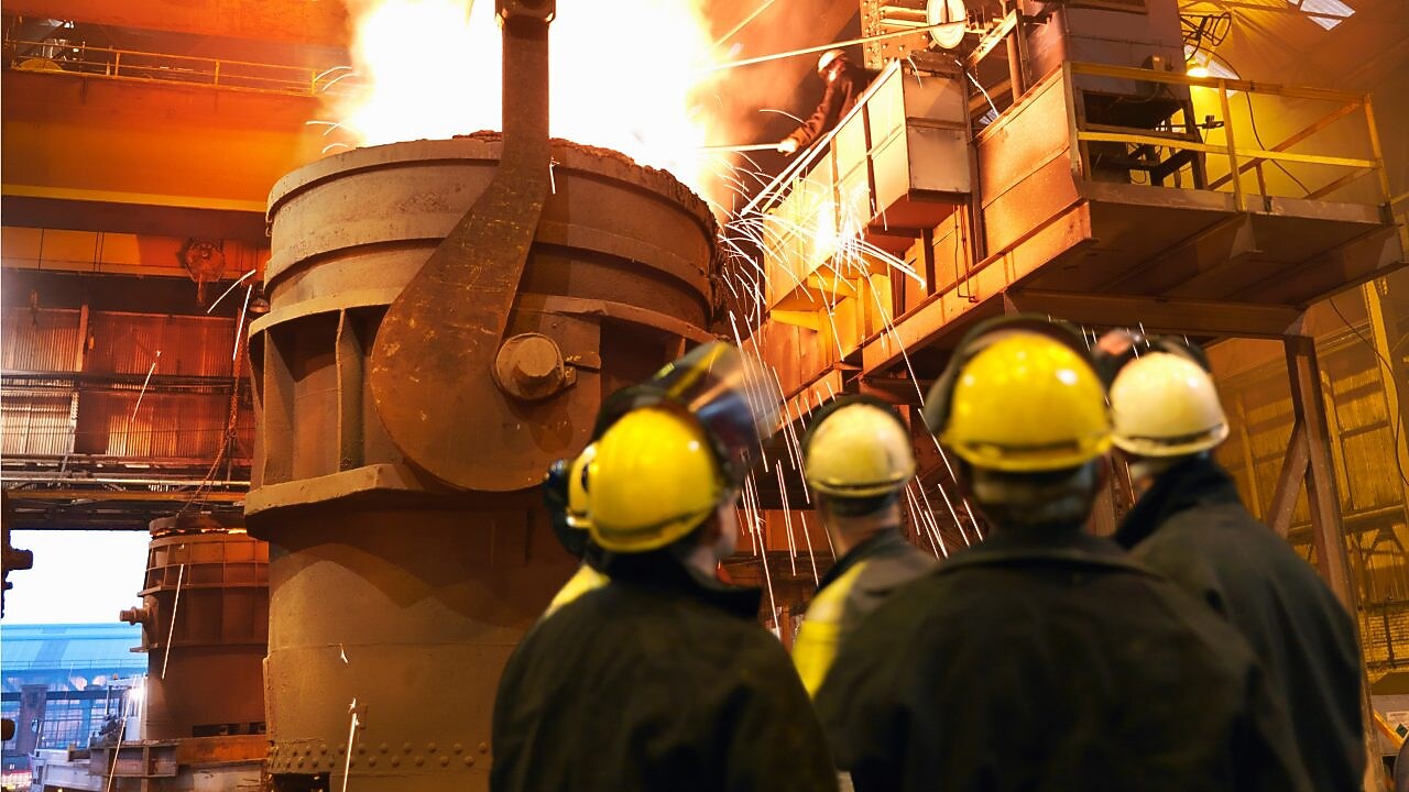 People in hard hats inspecting a furnace
