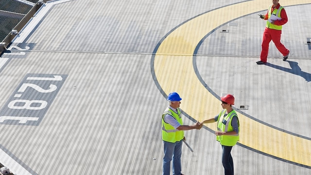 Two Shell employees shake hands as part of a partnership