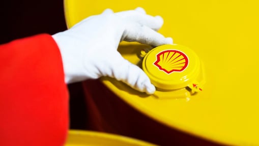 A Shell expert adjusts the lid of a barrel of lubricant displaying the Shell logo