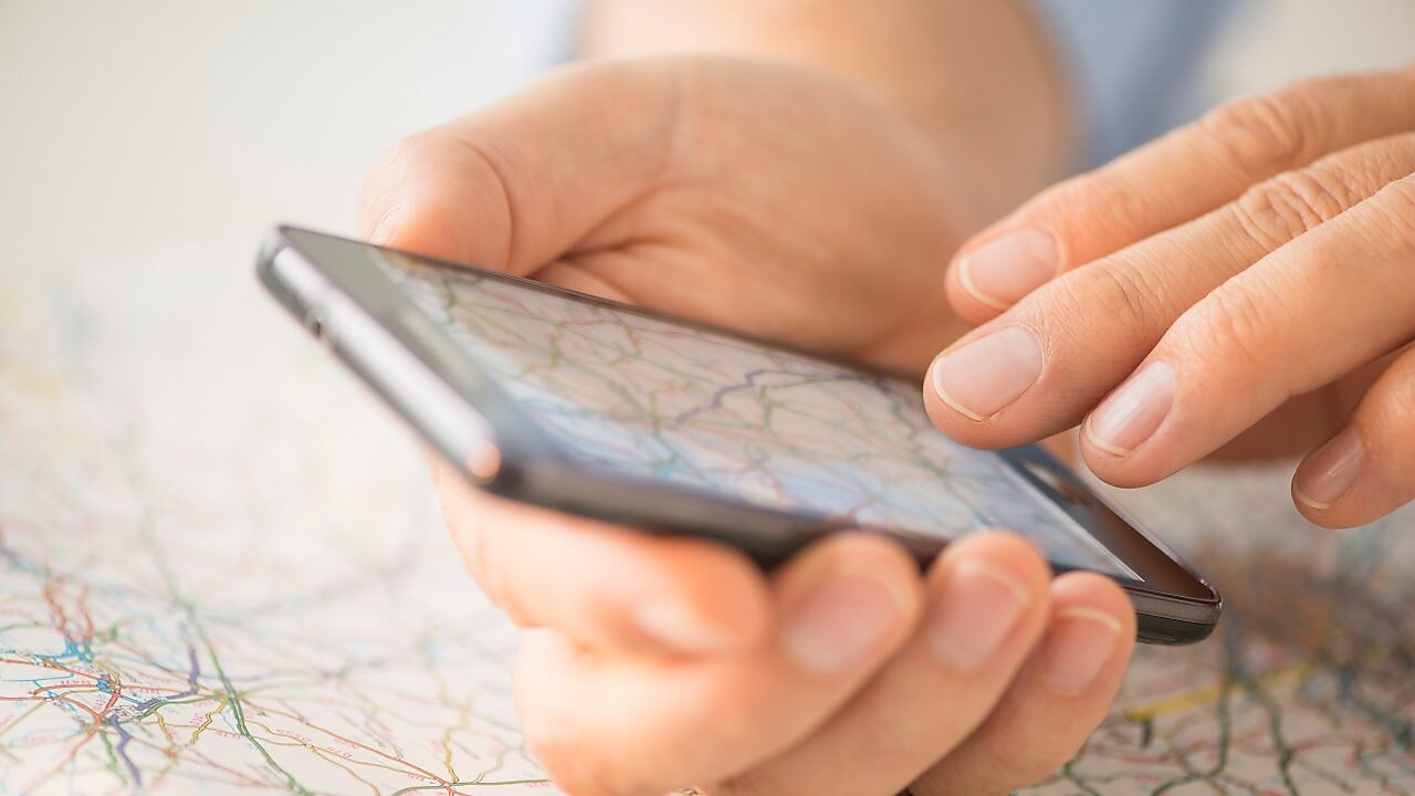 Close up of hand using smartphone over map
