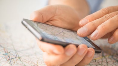 Close up of hand using smartphone over map