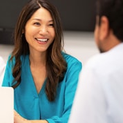 Women wearing blue blouse interacting with male.
