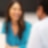 Women wearing blue blouse interacting with male.