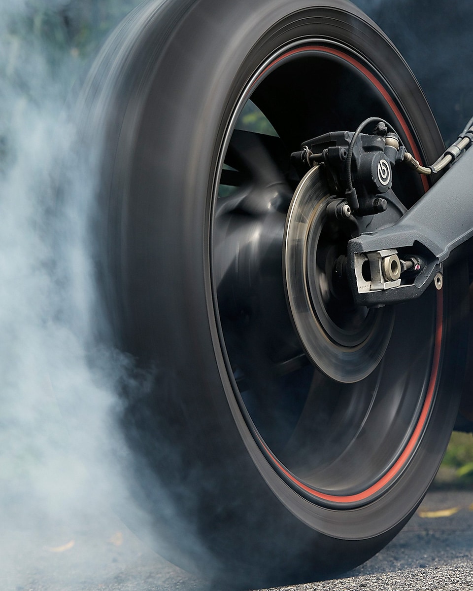 spinning motorcycle wheel producing a cloud of smoke