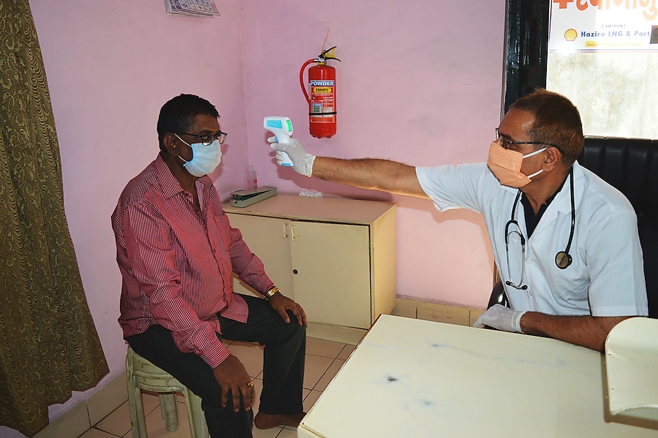 Dr Prakash Maradia takes the temperature of a patient