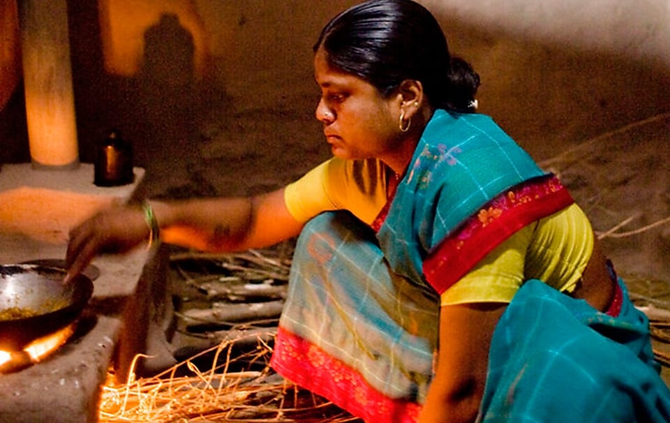 A woman cooks using traditional ‘chulha’